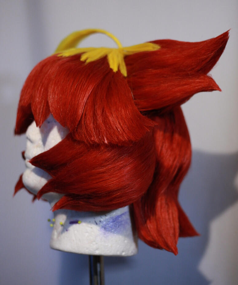 red and yellow cosplay wig styled to look like mela from pokemon scarlet and violet