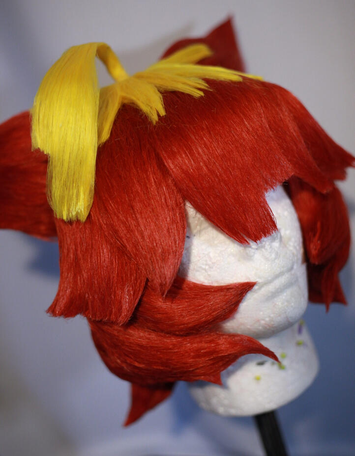 red and yellow cosplay wig styled to look like mela from pokemon scarlet and violet