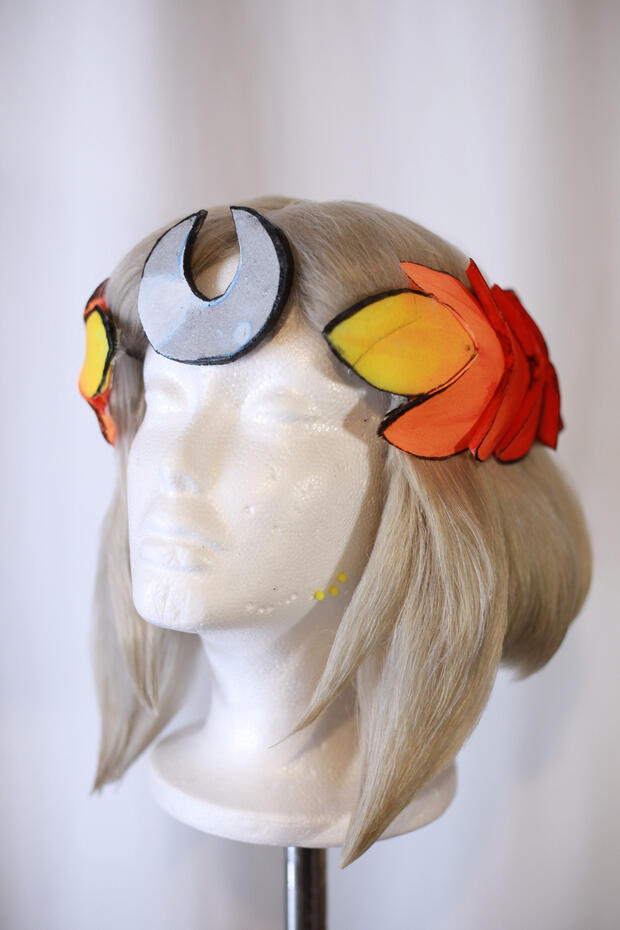 ashy blonde cosplay wig style to look like melinoe from hades, with a laurel made from eva foam painted to look glowy