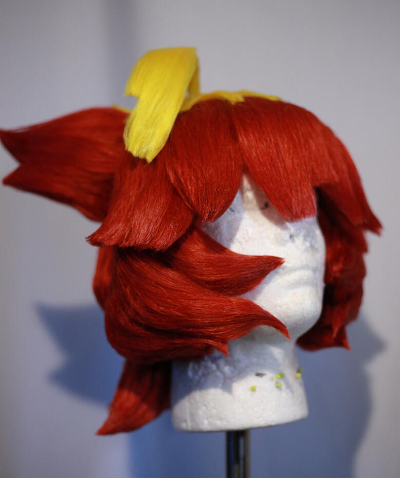 red and yellow cosplay wig styled to look like mela from pokemon scarlet and violet